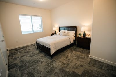 Bright interior of a private resident room with a bed
