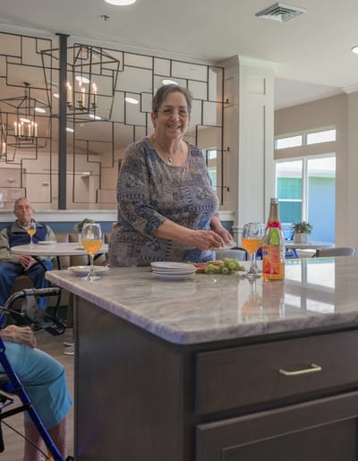 A resident preparing food in a common area kitchen