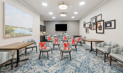 Bright common area with chairs and tables arranged.