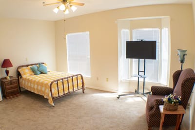 Cozy private bedroom with a bed and chair
