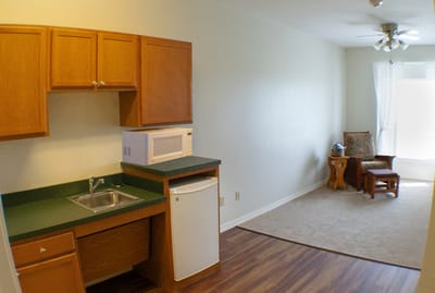Interior view of a resident's room with kitchenette