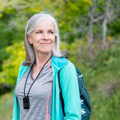 Rocky Mountain Care – Summit Ridge Assisted Living OC LLC, nursing home in Douglas, WY — Active senior woman outdoors with a backpack and pendant