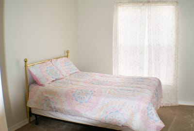 Neatly made bedroom with a gold bed frame