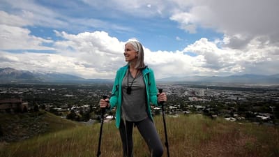 Rocky Mountain Care – Summit Ridge Assisted Living OC LLC, nursing home in Douglas, WY — Woman hiking in a scenic mountain landscape with city view