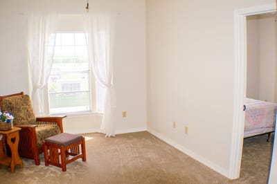 Bright, cozy resident room with a chair and natural light