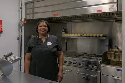 Staff member in a kitchen area preparing food