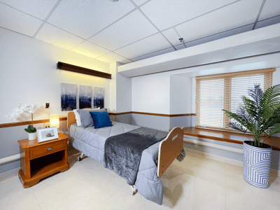 Interior view of a private resident room with a bed and decorations