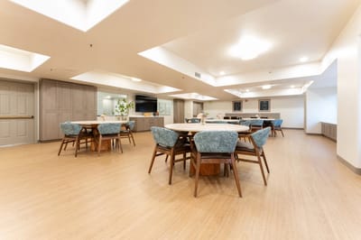 Common area with tables and chairs in a bright setting