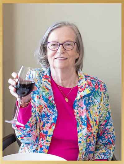 Resident enjoying a glass of wine in a colorful outfit