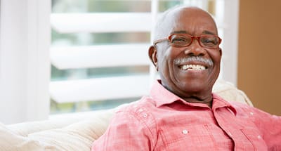 Senior man smiling warmly in a cozy sitting area
