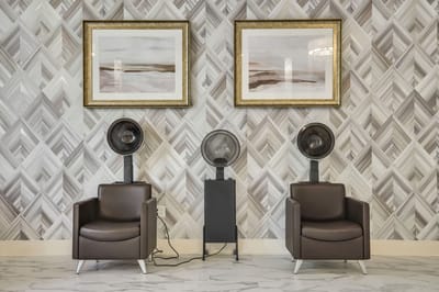 Hair salon setup with chairs and artwork on the walls