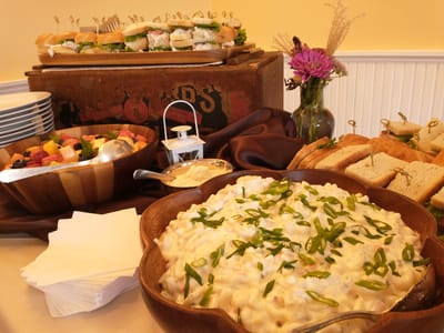 A beautifully arranged food display with macaroni salad and sandwiches