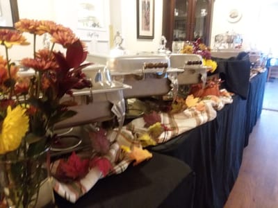 Buffet setup with decorative flowers and autumn leaves