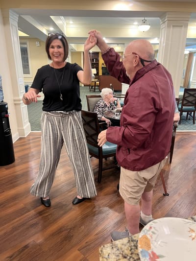 Residents and staff dancing in a common area