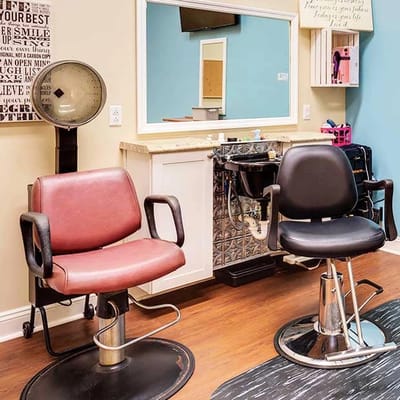 Hair salon area with styling chairs and mirrors