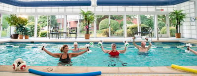 Residents participating in water aerobics class in a pool