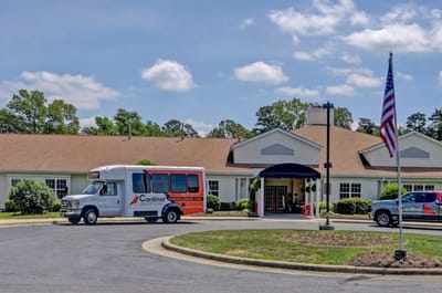 Exterior view of Cardinal Senior Communities facility with transport vehicles