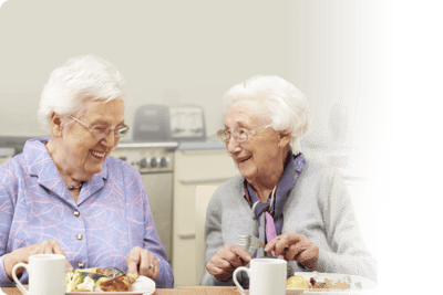 Two elderly women enjoying a meal together