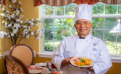 Chef presenting a colorful meal in a dining area