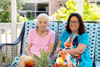 Two residents enjoying drinks on an outdoor patio