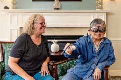 A resident participating in an activity with staff assistance
