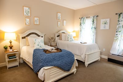 Brightly decorated resident room with two beds and floral accents