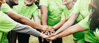 Volunteers joining hands in a community activity