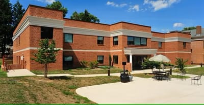 Exterior view of a brick building with outdoor seating
