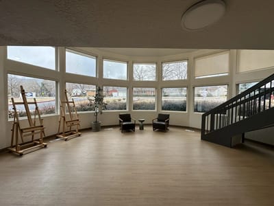 Bright common area with seating and large windows