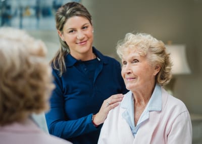 A caregiver interacting with a smiling resident