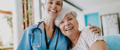 A smiling caregiver with a resident
