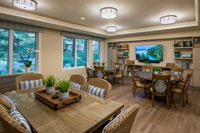 Bright common area with dining tables and windows