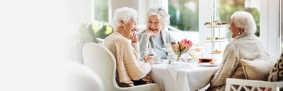 Residents enjoying tea and pastries at a dining table