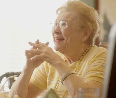 Smiling senior woman with glasses looking cheerful
