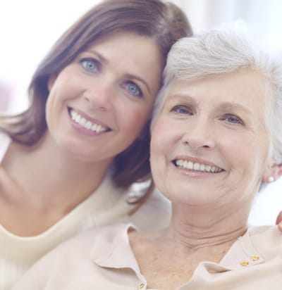 A smiling senior woman with a caregiver