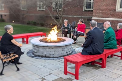 Residents gathered around a fire pit in a courtyard