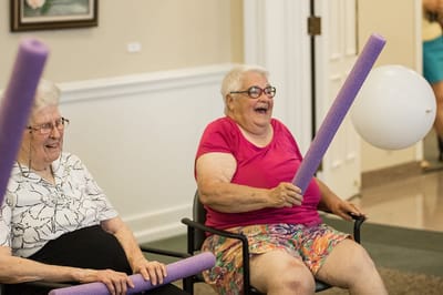 Residents participating in a fun activity with pool noodles