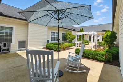 Outdoor seating area with parasol and greenery