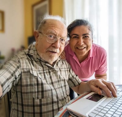 Senior resident with staff member smiling for a photo