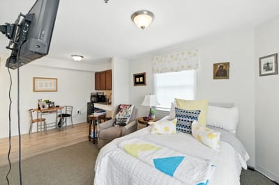A cozy resident room with a bed and dining area