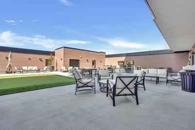 Outdoor patio area with seating and putting green