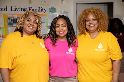 Three staff members posing together in bright shirts