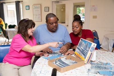 Residents and staff collaborating on a puzzle activity