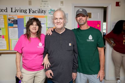 Residents and staff posing together in a common area
