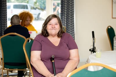 Resident seated at a table in a communal area.