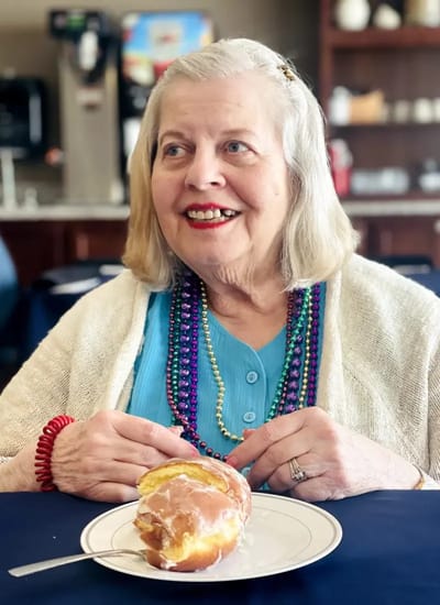 Resident enjoying a donut at a dining table