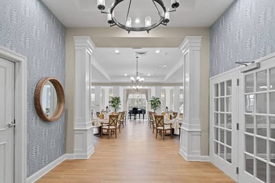 Bright common area with dining tables and piano