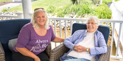 Staff member with a resident outdoors, both smiling