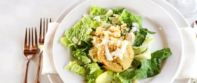 A salad with lettuce and toppings on a plate