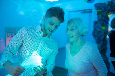 Staff member engaging with a resident in an activity room